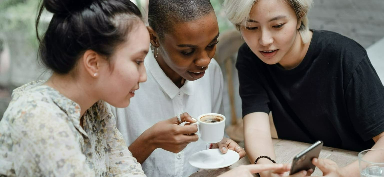 Image of group of diverse females looking at a mobile device
