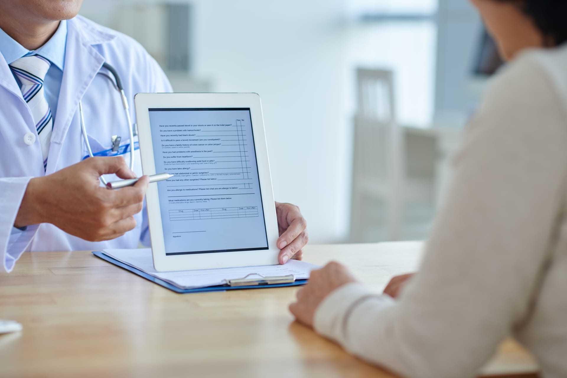 Doctor reviewing patient information on a digital tablet