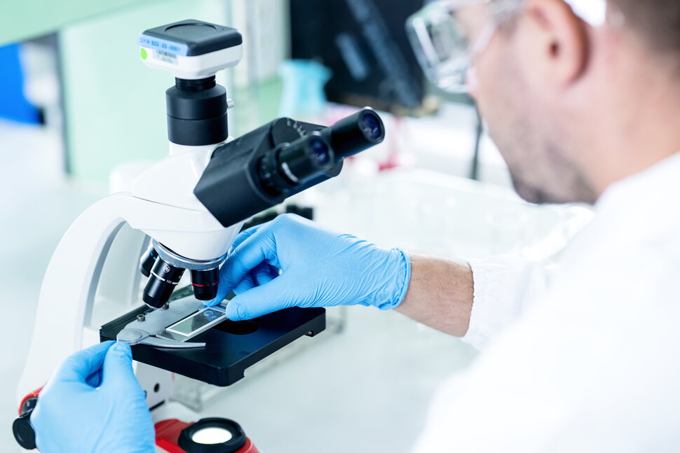 Researcher examining a sample under a microscope in a laboratory