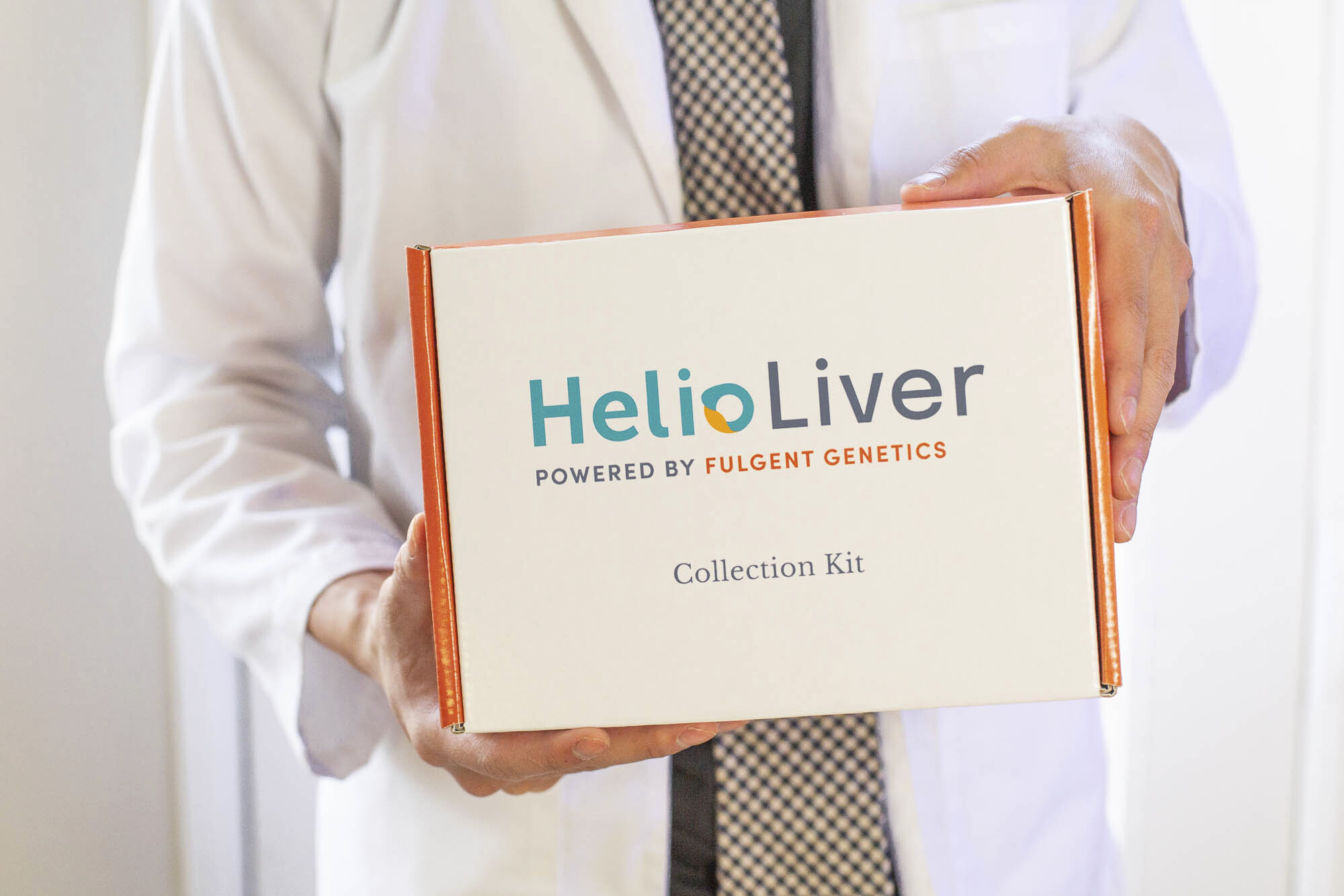 A clinician holding a HelioLiver Collection Kit box
