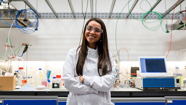 A scientist in a white coat and goggles in a laboratory