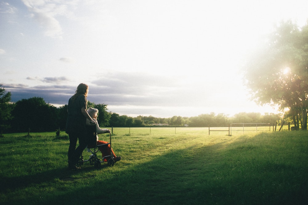 A caregiver supporting a loved one outdoors at sunset